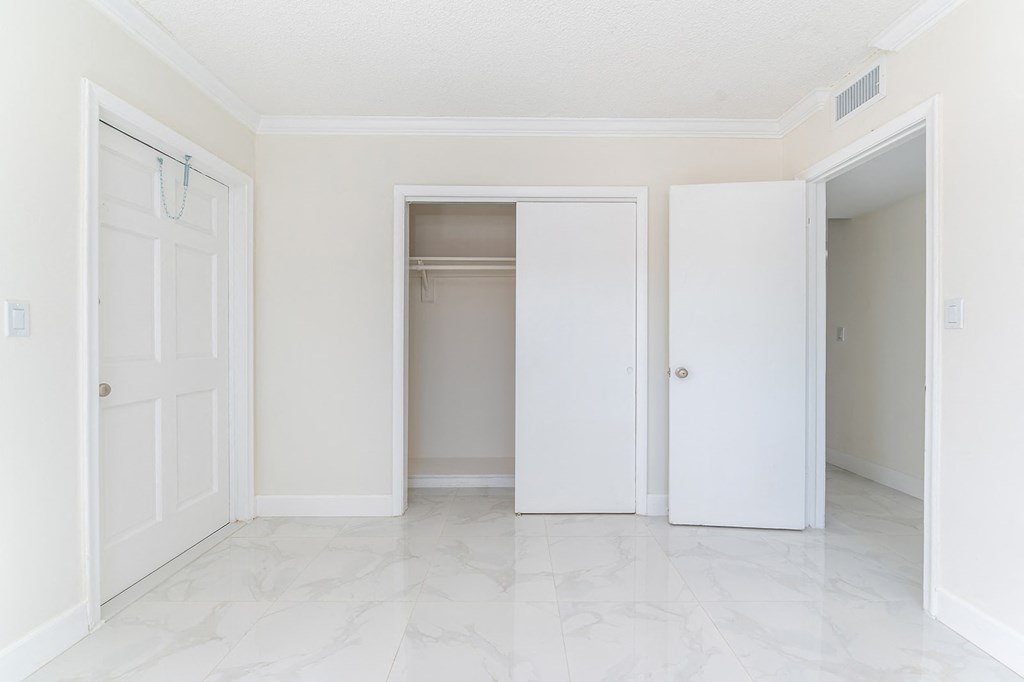 an empty room with three doors and a closet