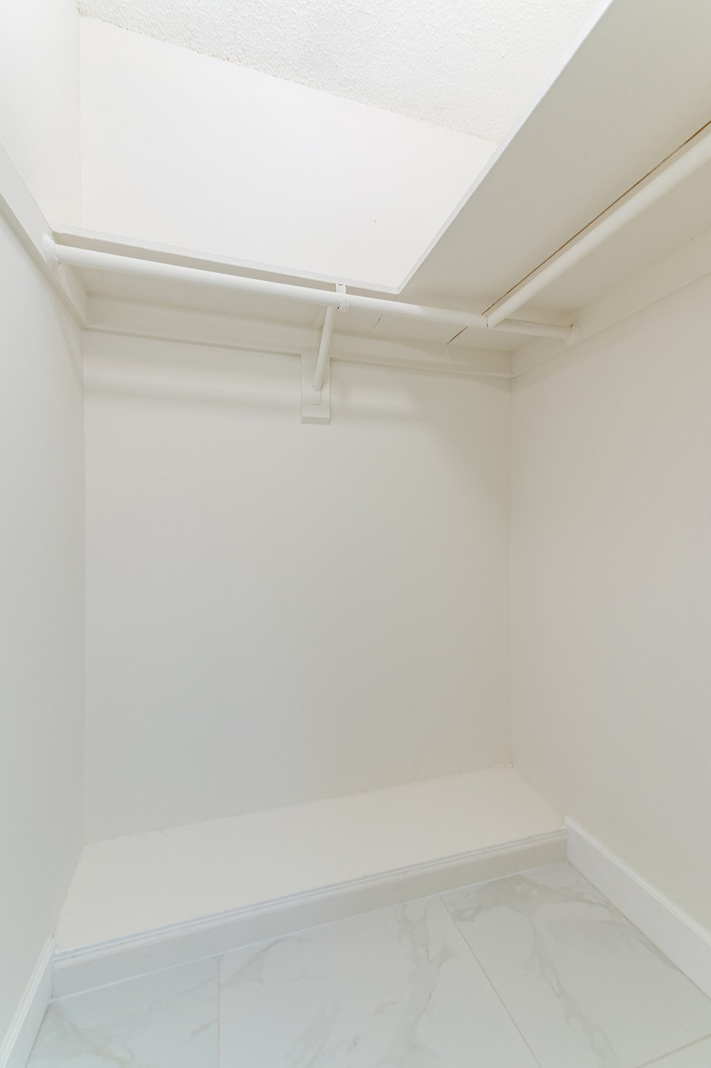 an empty room with white walls and a white fluorescent light on the ceiling