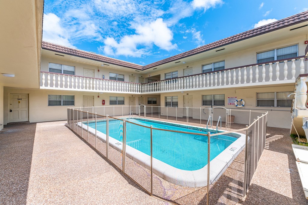 a swimming pool in a building with a fence around it