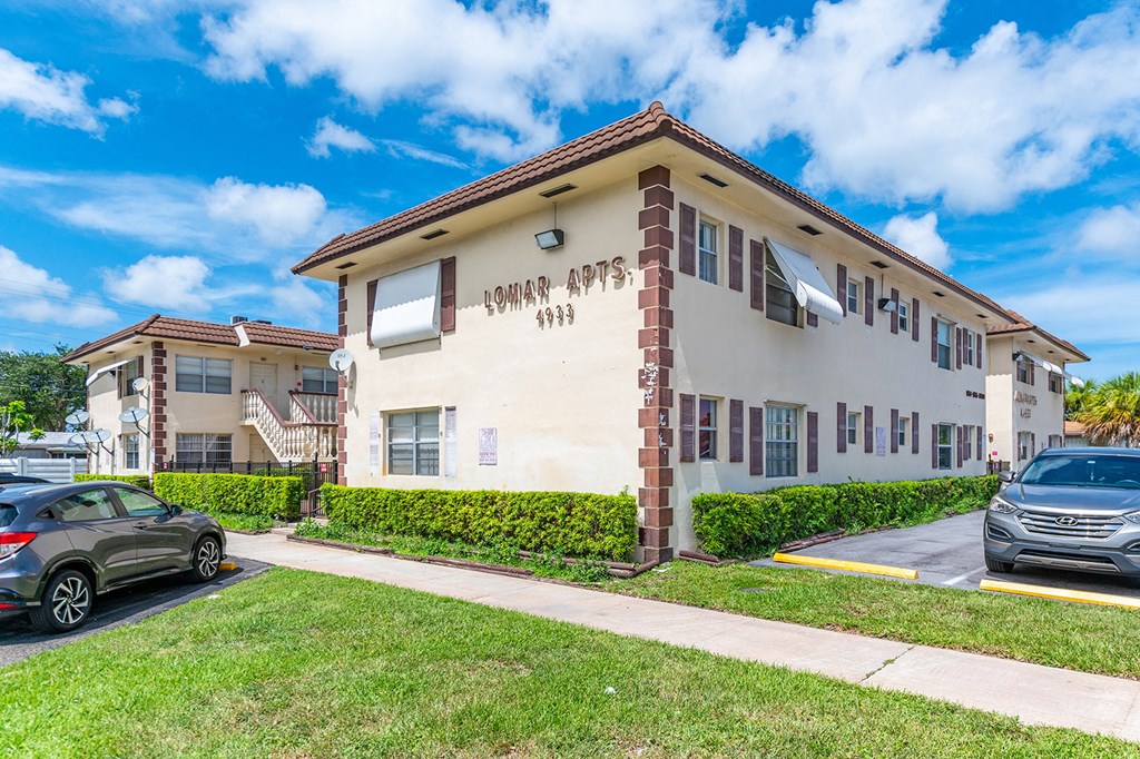 an apartment building with cars parked in front of it