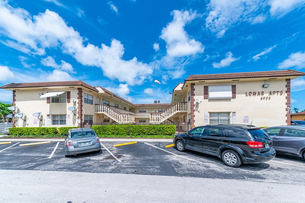 a parking lot with cars in front of a building