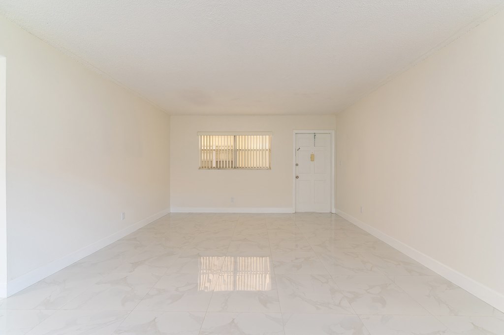 an empty living room with white walls and a white door