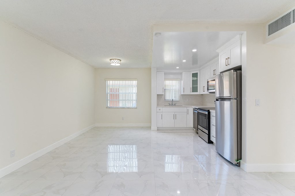 an empty kitchen with stainless steel appliances and tile flooring