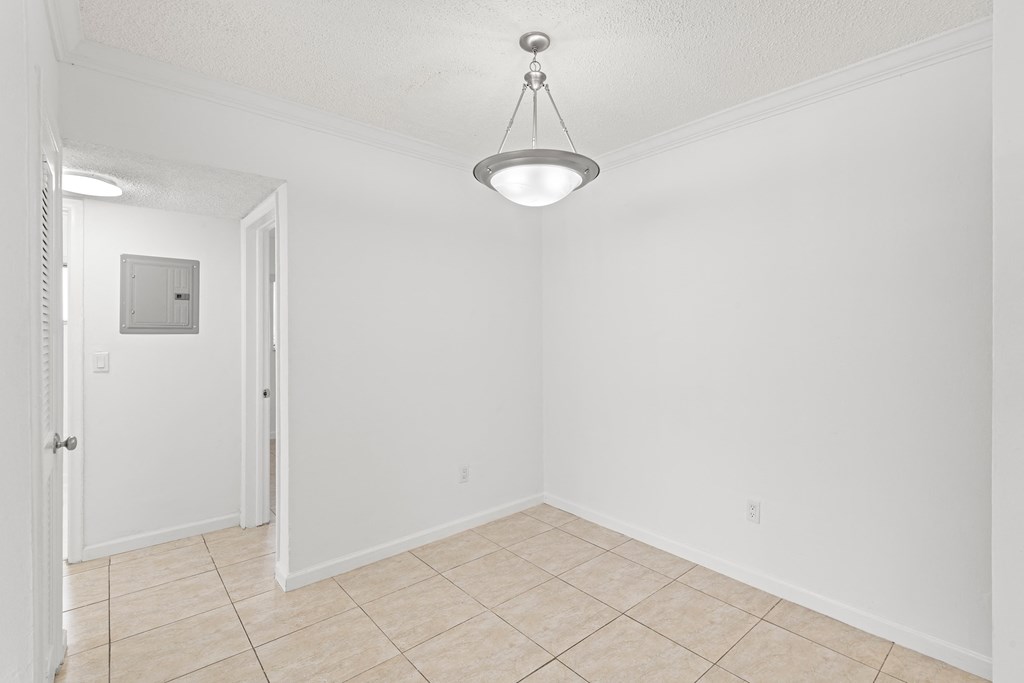 an empty living room with a light hanging from the ceiling