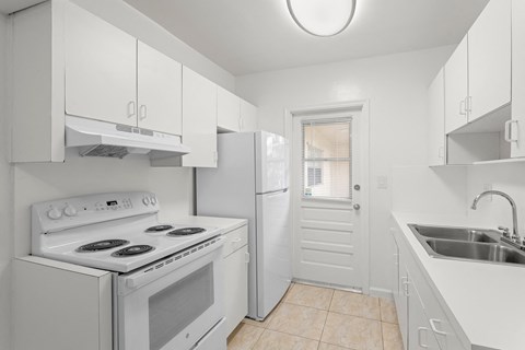 a white kitchen with white appliances and white cabinets