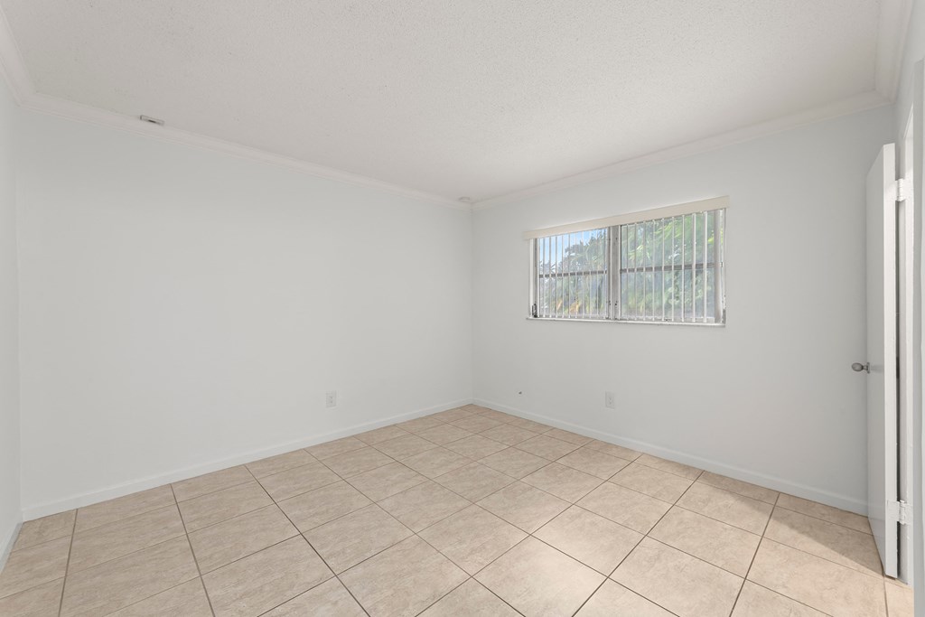 the living room of an empty home with a tiled floor