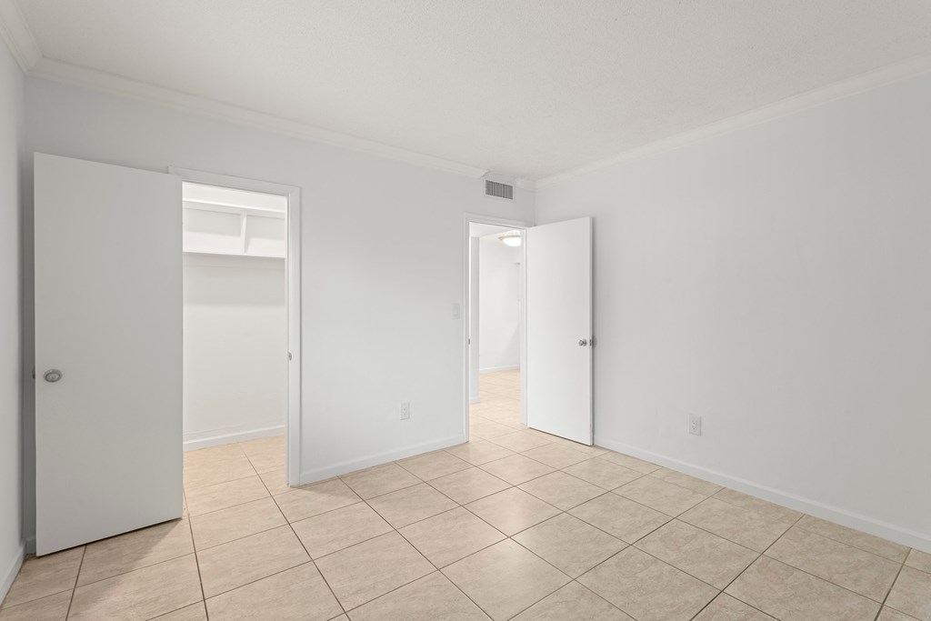 the living room of a house with white walls and a tiled floor