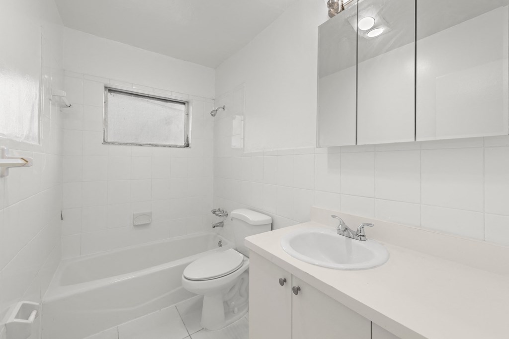 a white bathroom with a sink toilet and tub
