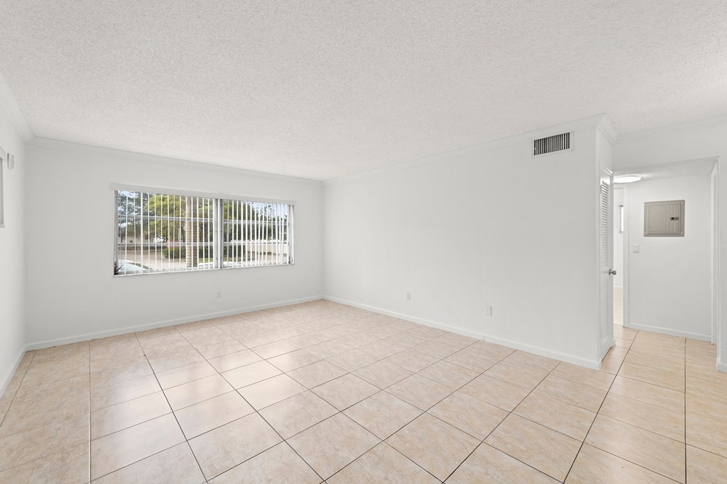 the living room and dining room of a house with tiled floors and a window
