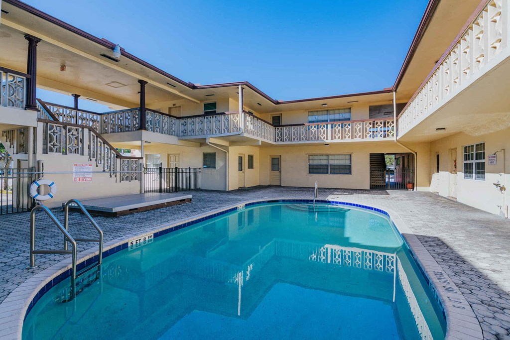 a swimming pool in front of a building with a pool