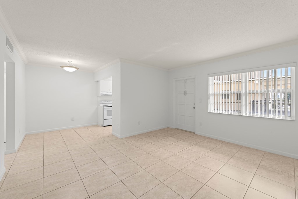 the living room and kitchen of an empty house with a large window