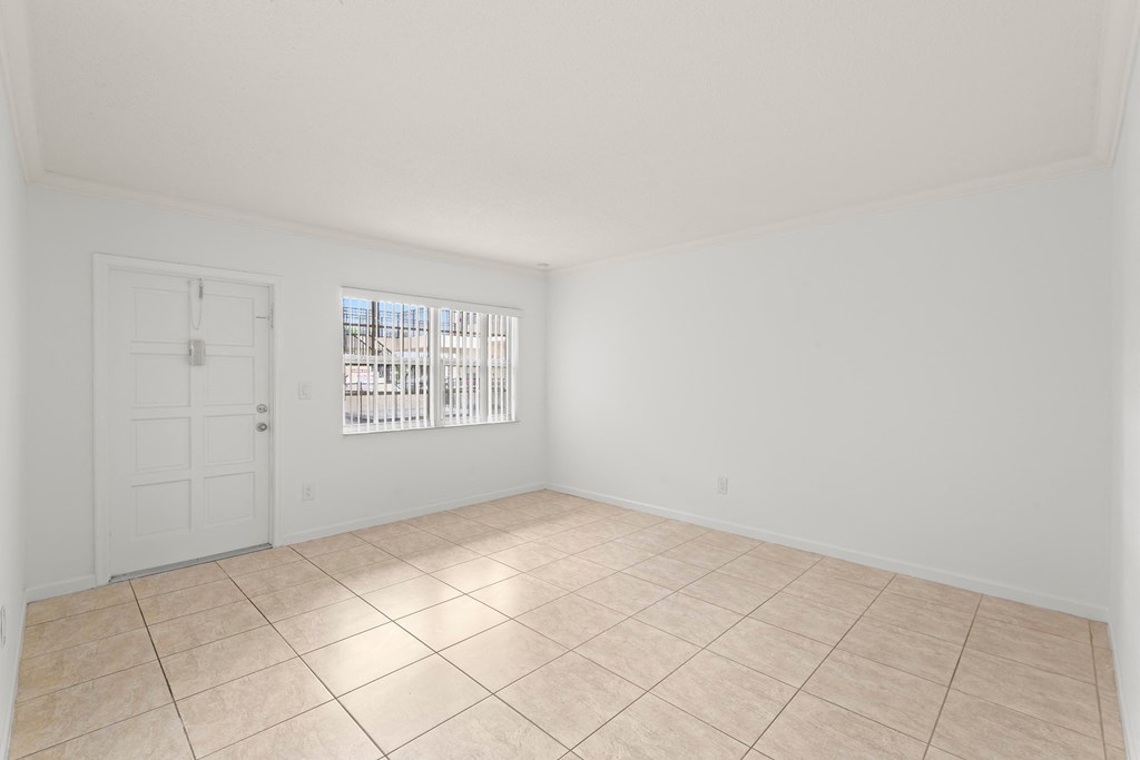 the living room of a home with a tiled floor and a white door