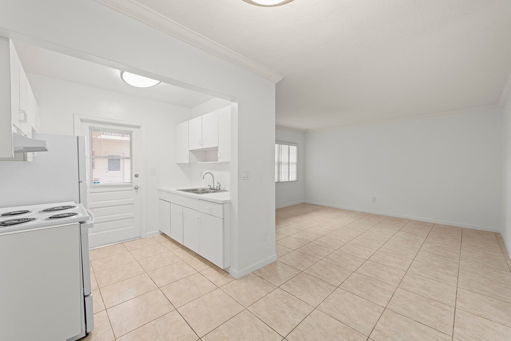 an empty kitchen with a stove and a sink