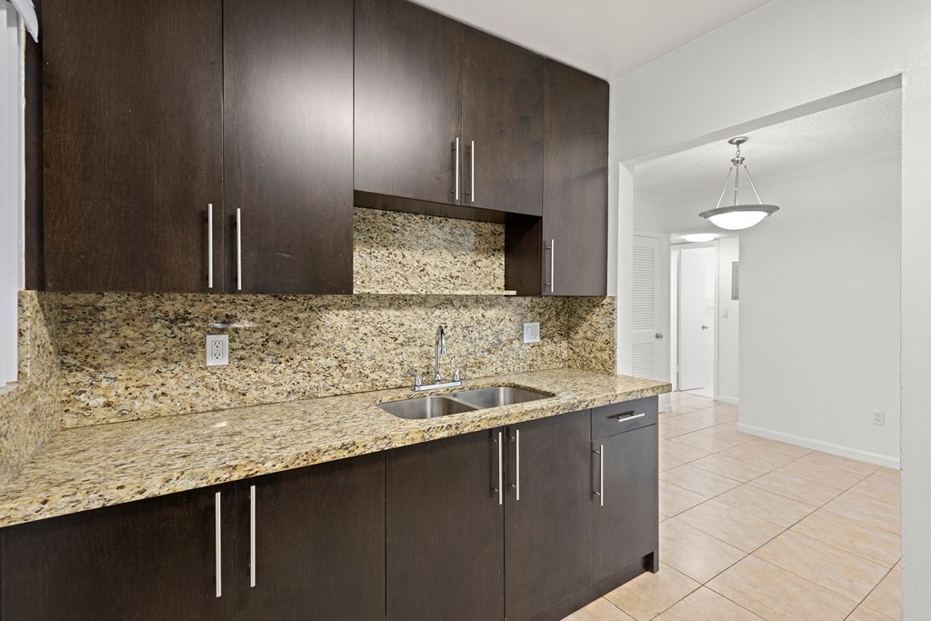 a kitchen with a granite counter top and wooden cabinets