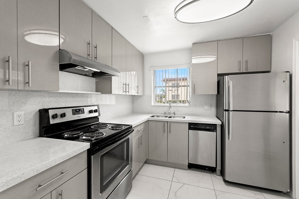 a kitchen with stainless steel appliances and white counter tops
