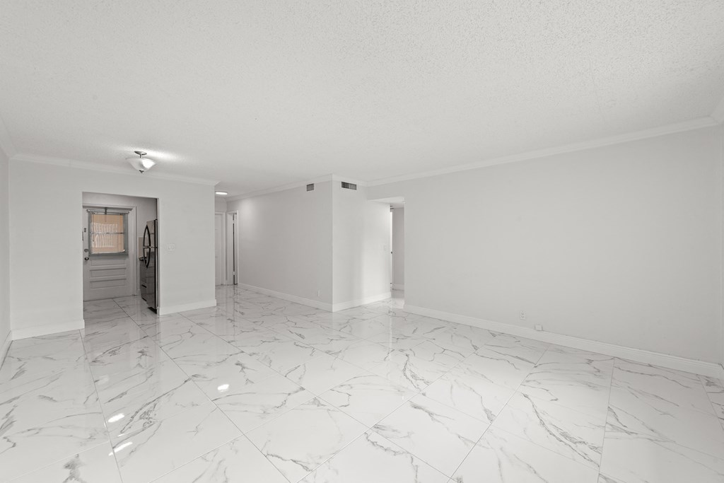an empty living room with marble floor and white walls