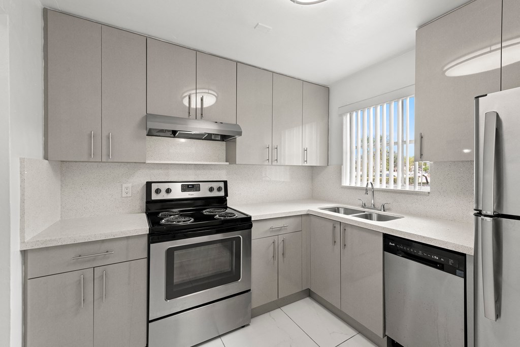 a modern kitchen with stainless steel appliances and white counter tops