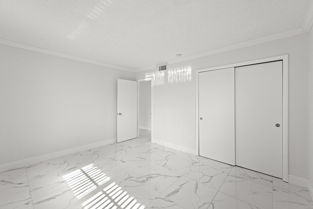 an empty living room with white walls and white marble floors