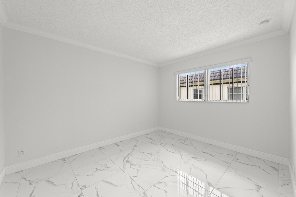 an empty room with white marble floors and a window