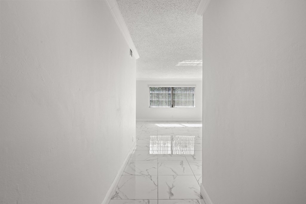 an empty room with a window and white walls