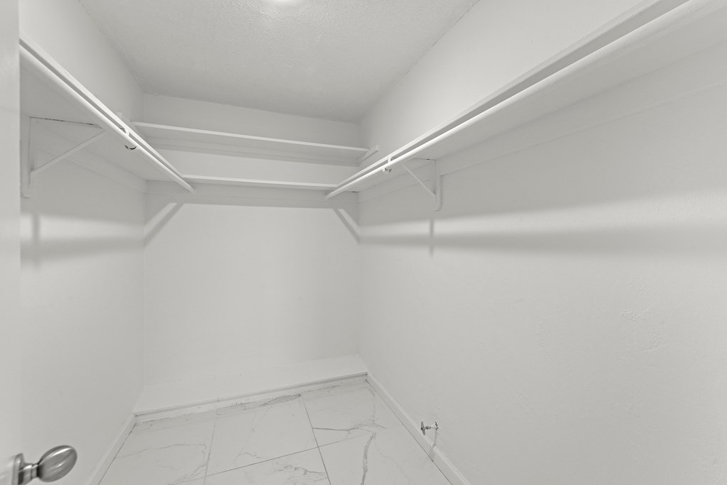 an empty room with white walls and a white tile floor