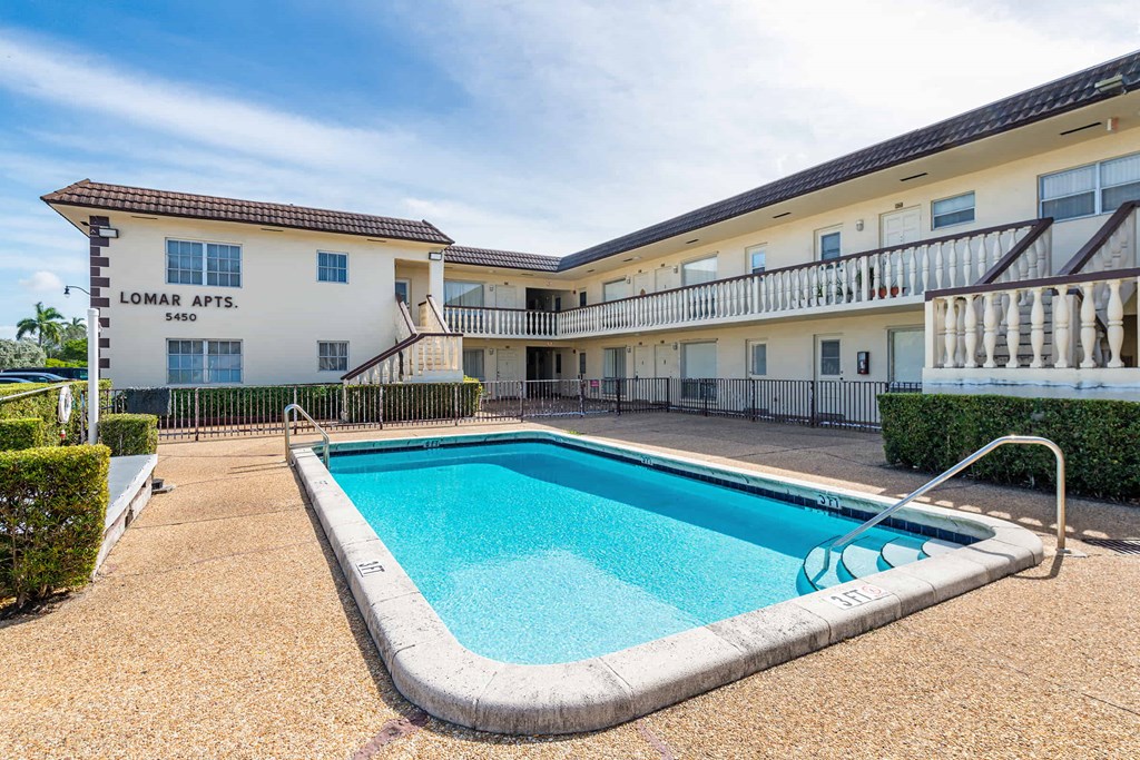 a swimming pool in front of a hotel with a pool