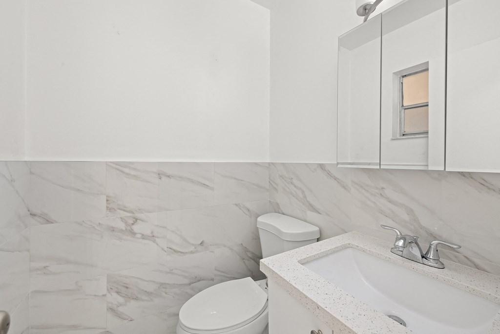 a white bathroom with a sink and a toilet