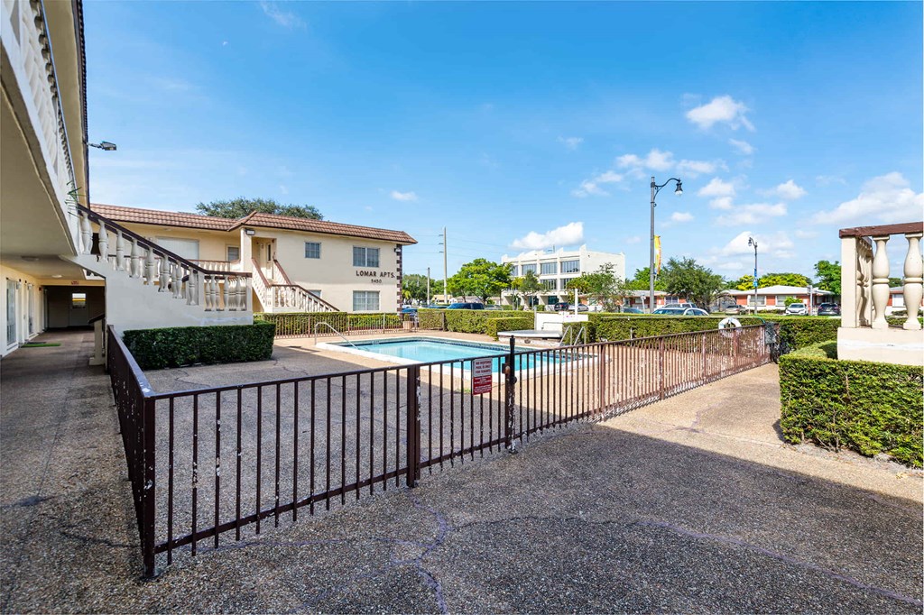 the pool is behind a wrought iron fence with a pool