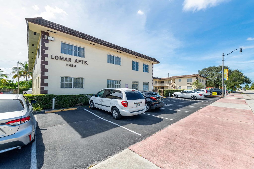 a parking lot with cars parked in front of a building