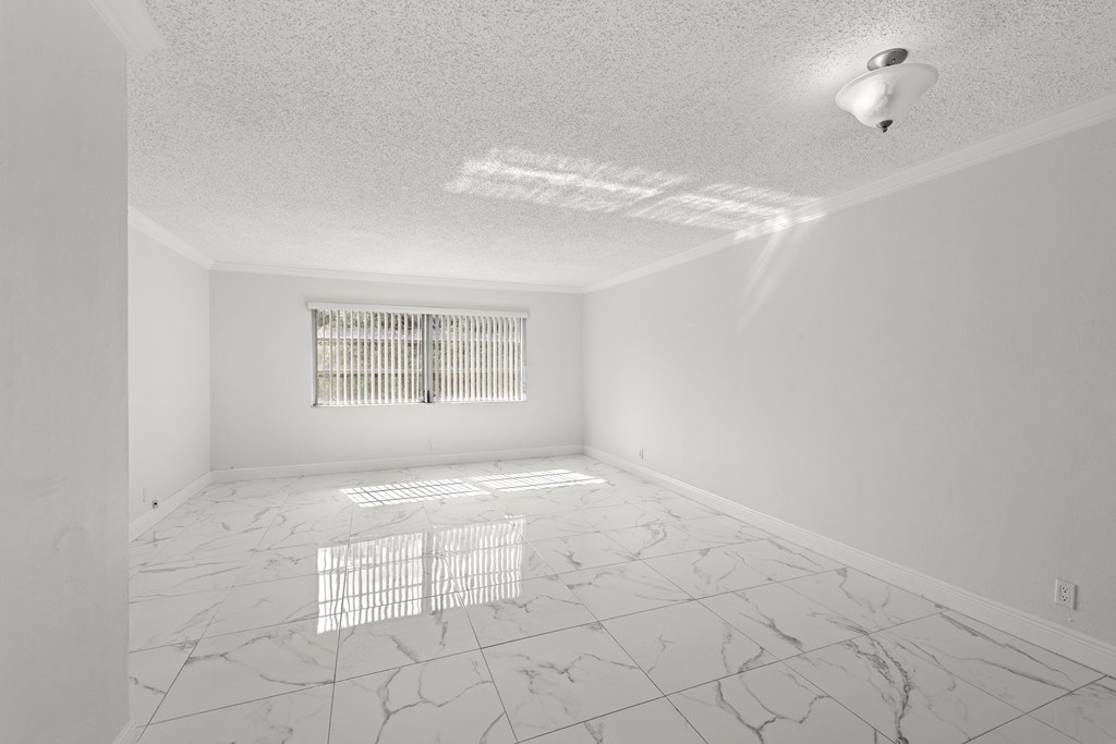 an empty room with a window and marble floor