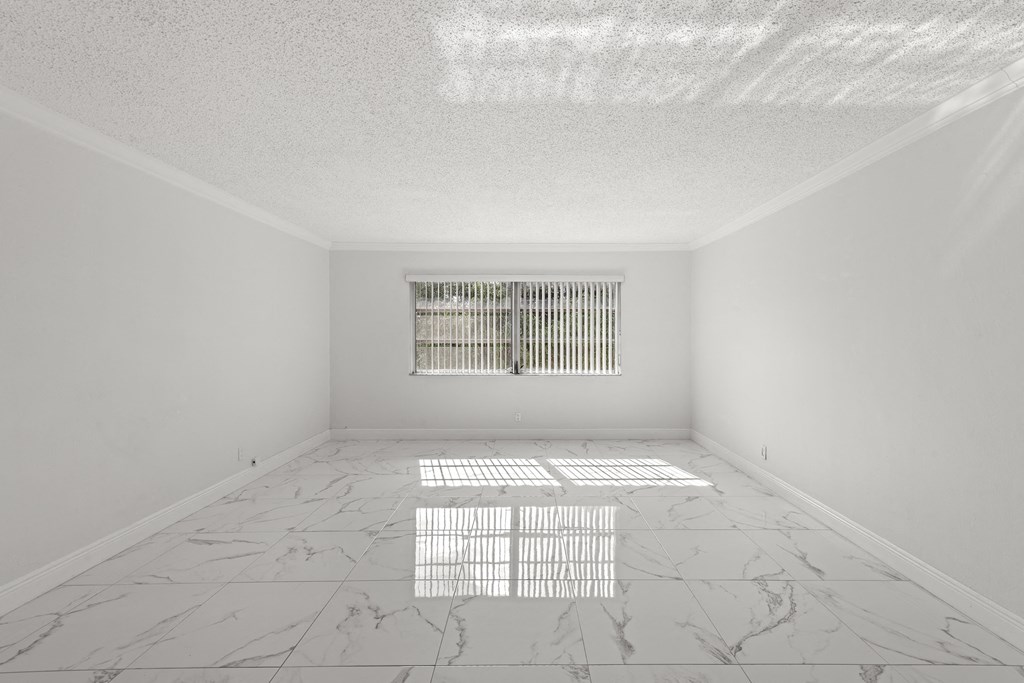 an empty room with a window and marble floors