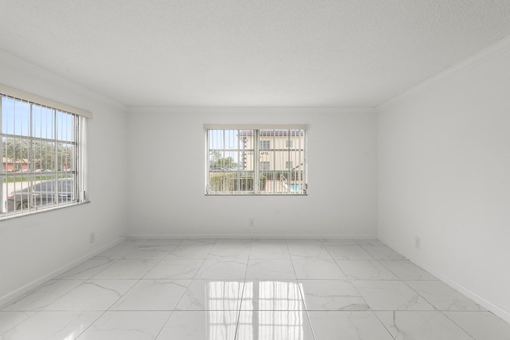 an empty room with two windows and a tiled floor