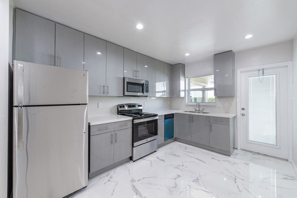 a white and gray kitchen with stainless steel appliances