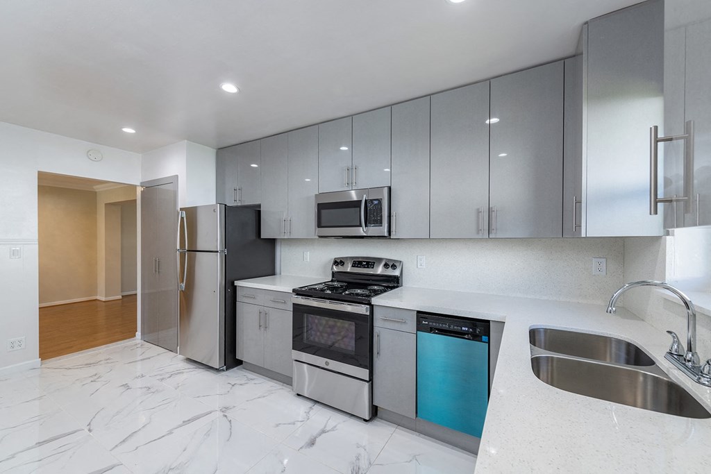 a modern kitchen with stainless steel appliances and white counter tops