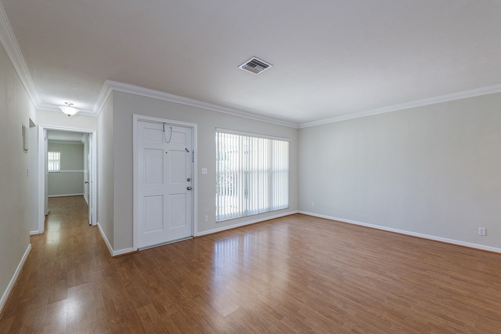 an empty living room with wood flooring and a white door
