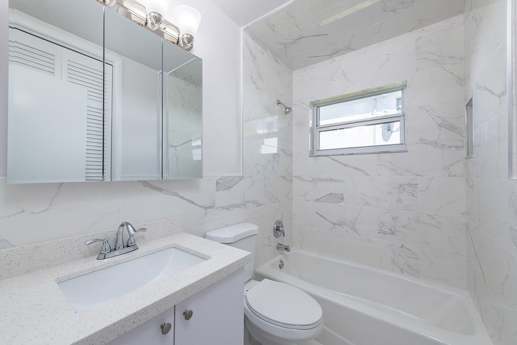 a white bathroom with a sink toilet and tub