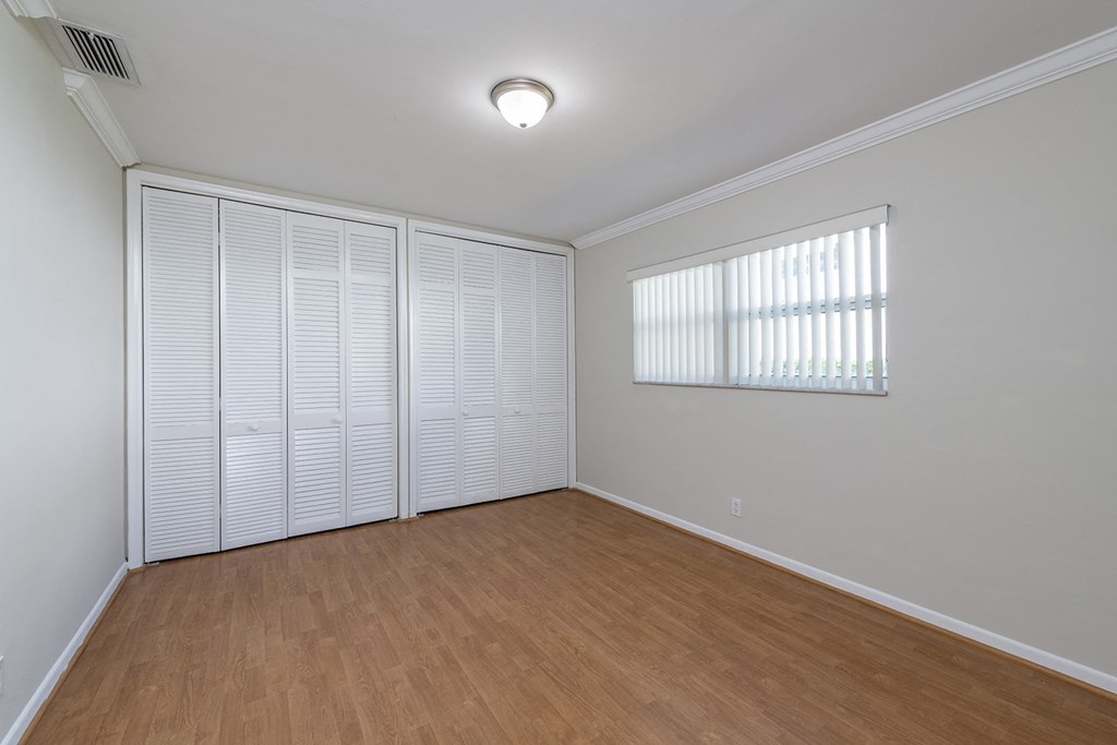 an empty living room with a large closet and a window