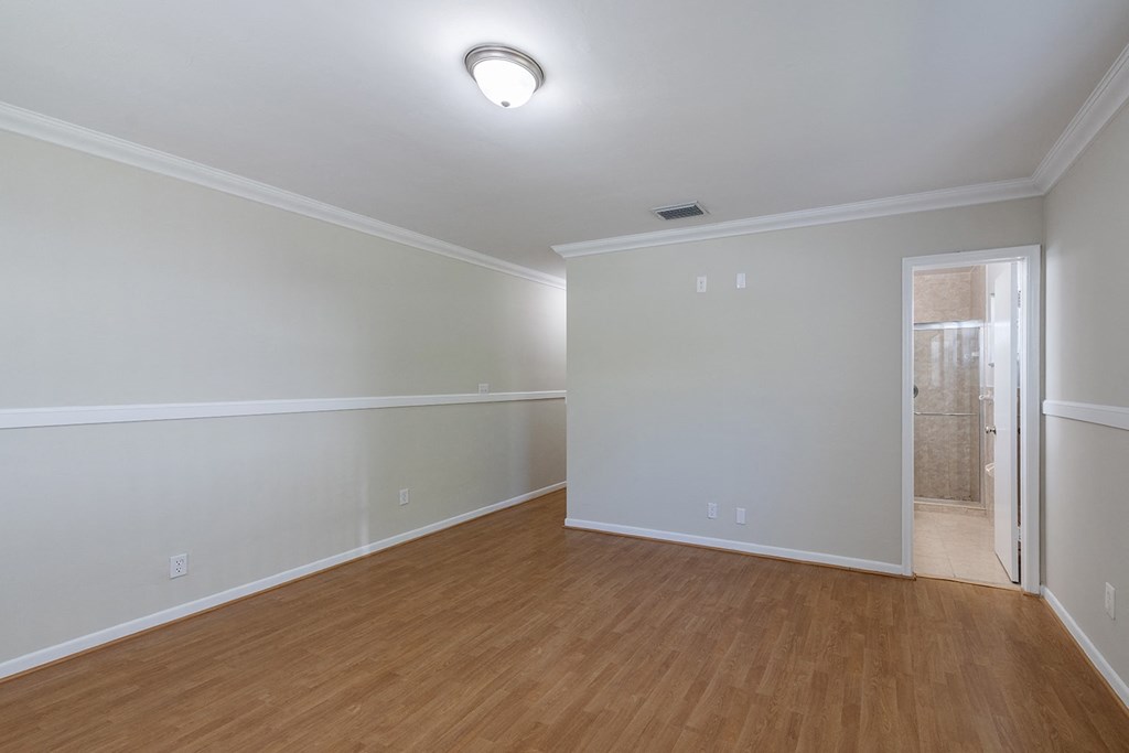 an empty living room with wood flooring and white walls
