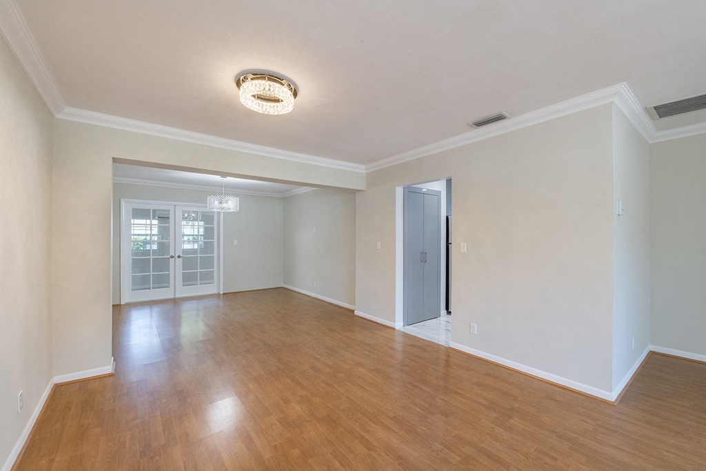 an empty living room with wood flooring and white walls
