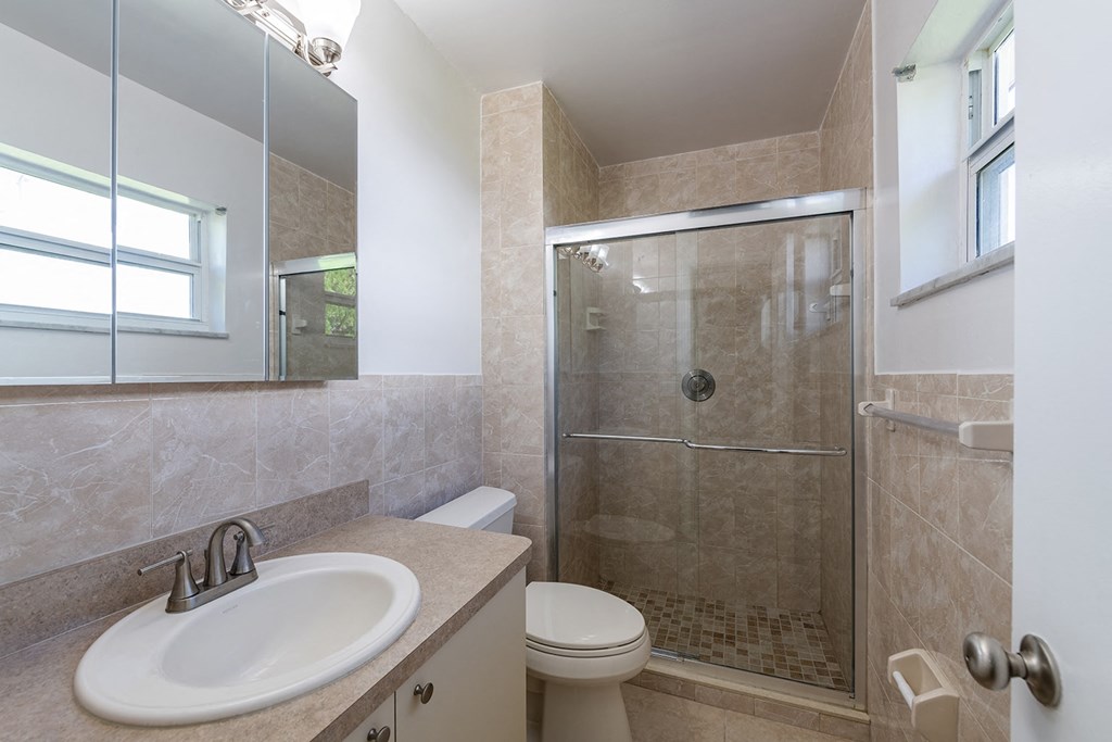 a bathroom with a sink toilet and shower