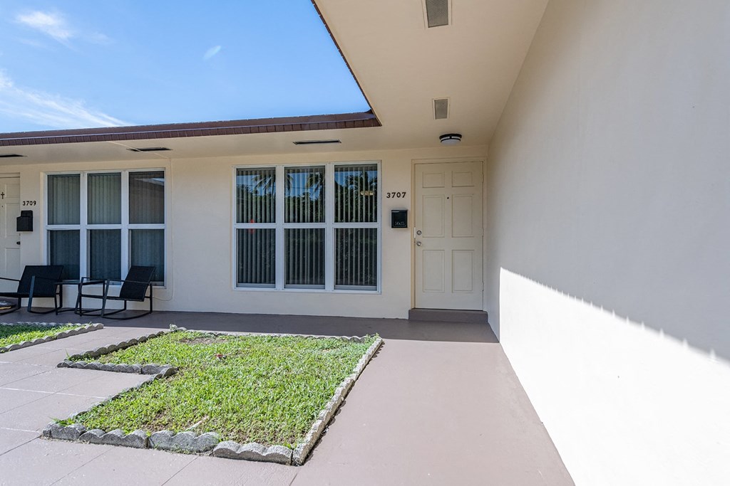 a patio with a lawn in front of a building