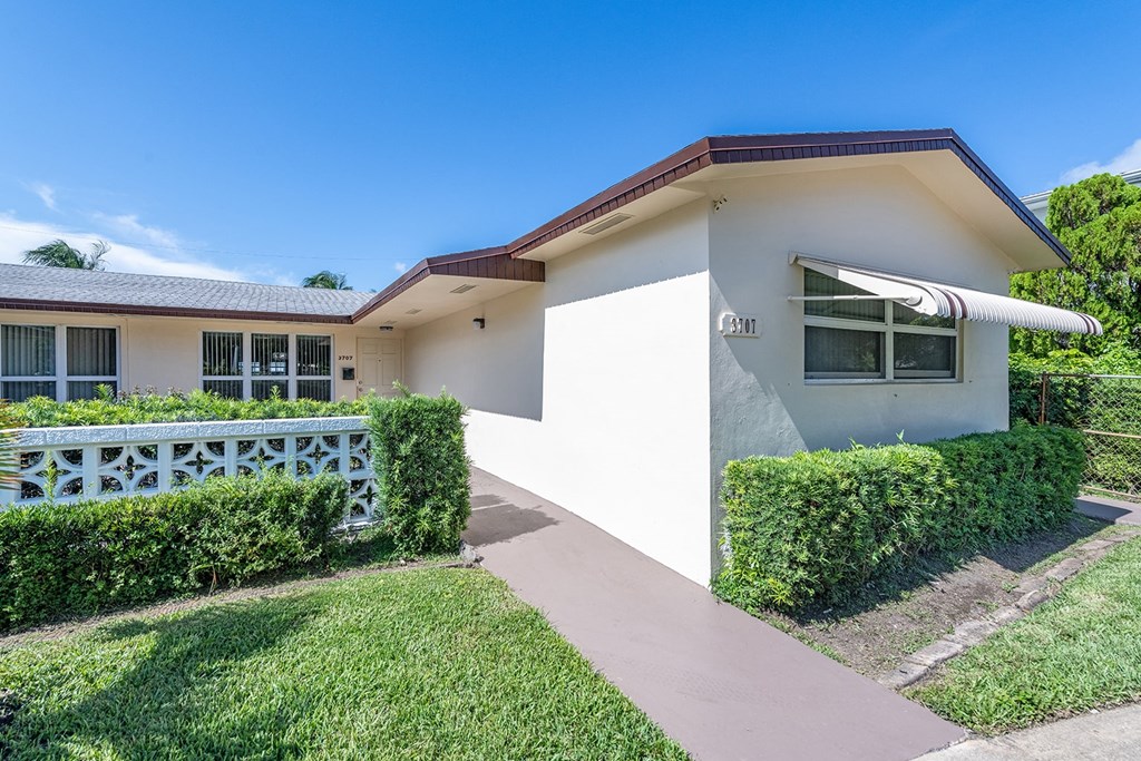 a white house with a porch and a white fence
