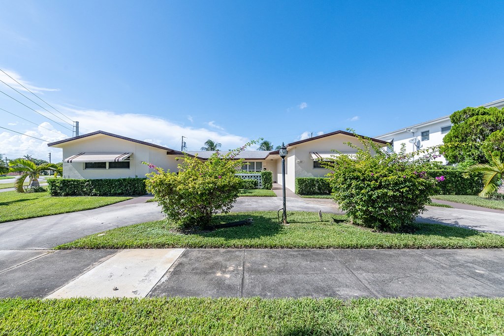 two houses in a neighborhood with lawns and trees
