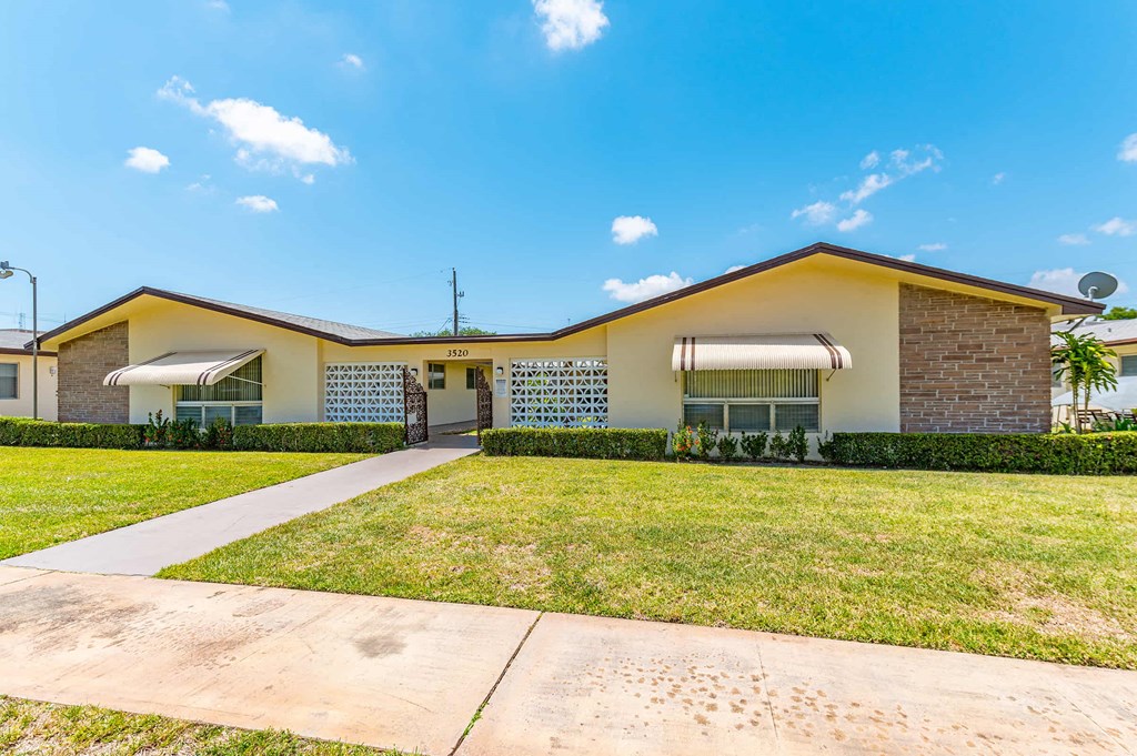 a house with a lawn and a sidewalk in front of it