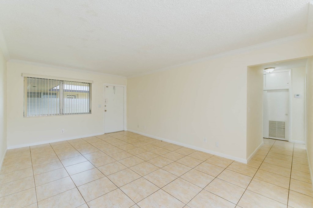 the living room and dining room of an empty house with tile flooring