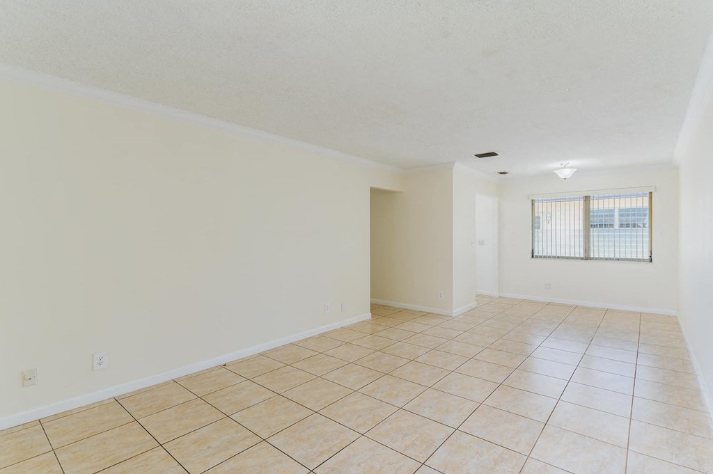 a spacious living room with tile flooring and a window