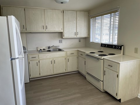 a kitchen with white cabinets and a stove and a refrigerator