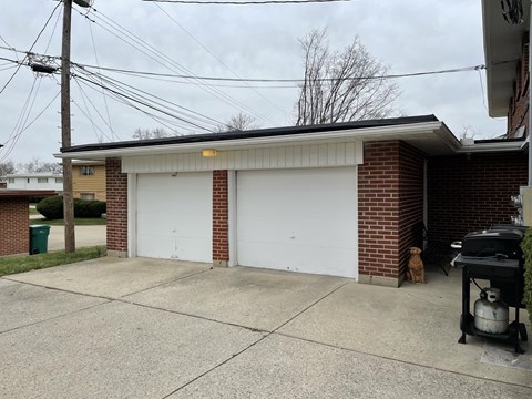 a white garage door in front of a brick building