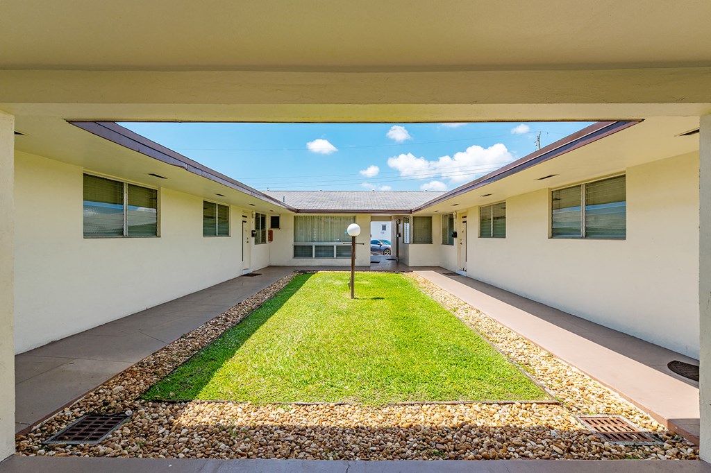 a view of a courtyard in a building with grass