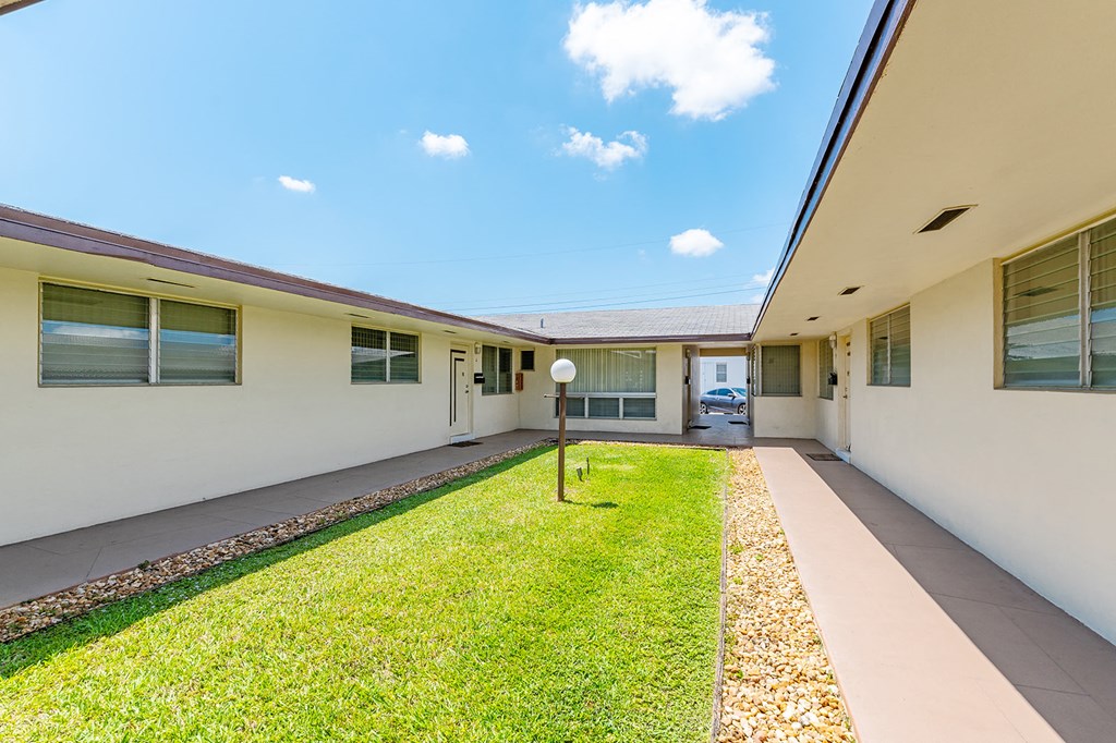 a yard in front of a house with a grass lawn